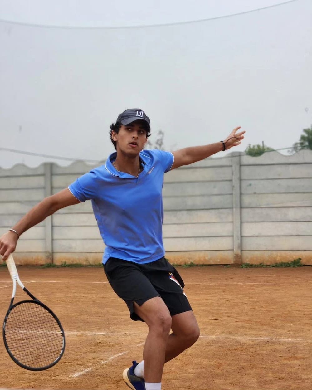 Young tennis player training on court